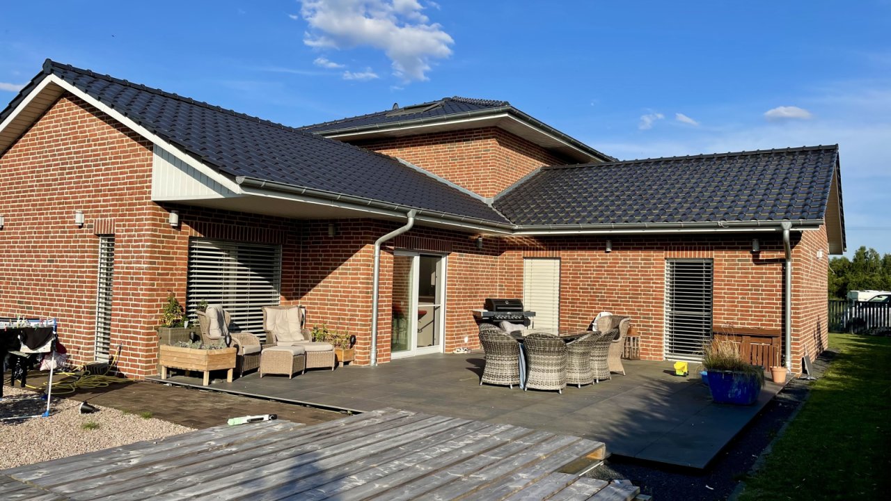 Blick vom Garten auf die Terrasse und Pool